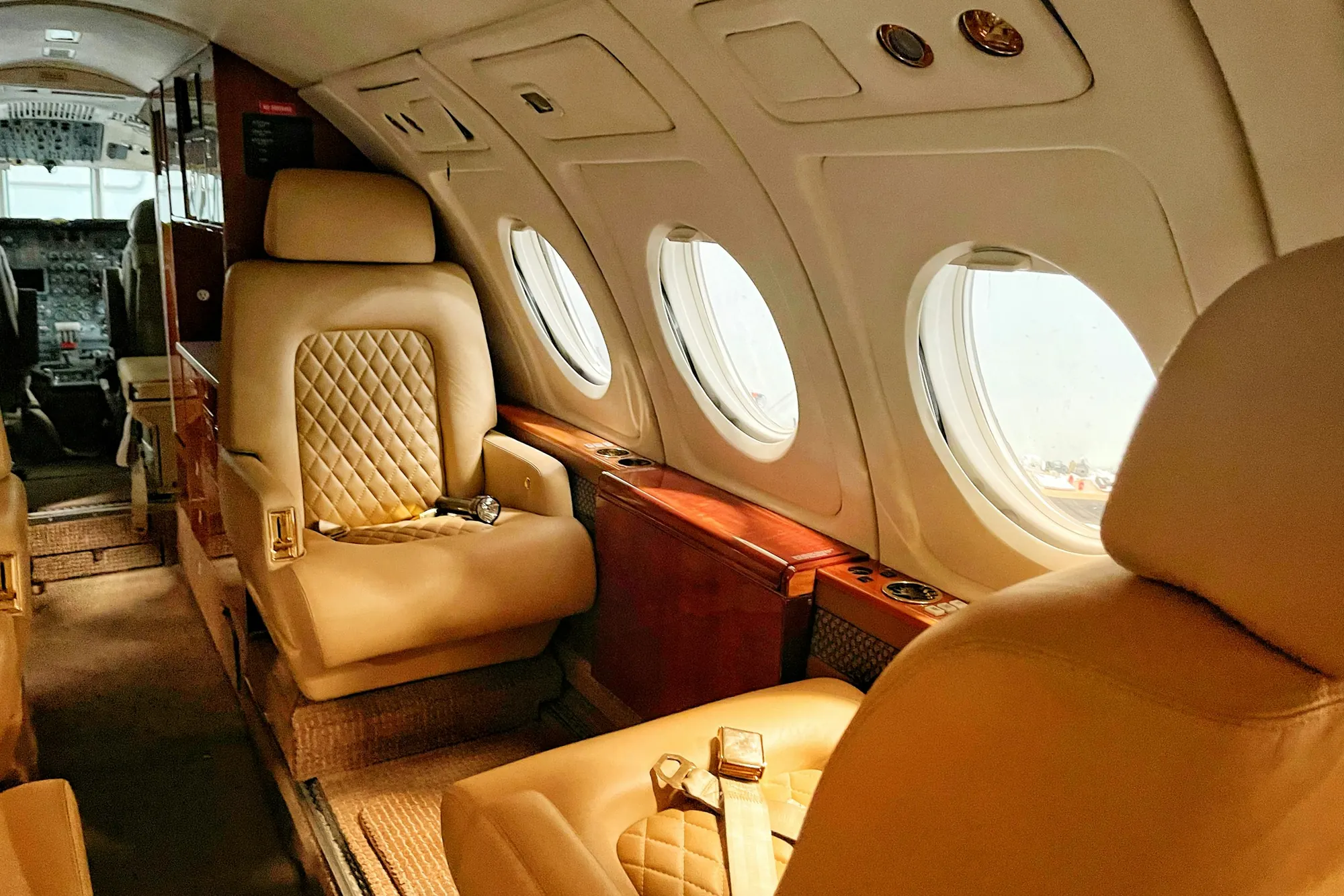 Quilted leather club seats and oval windows in a business jet cabin