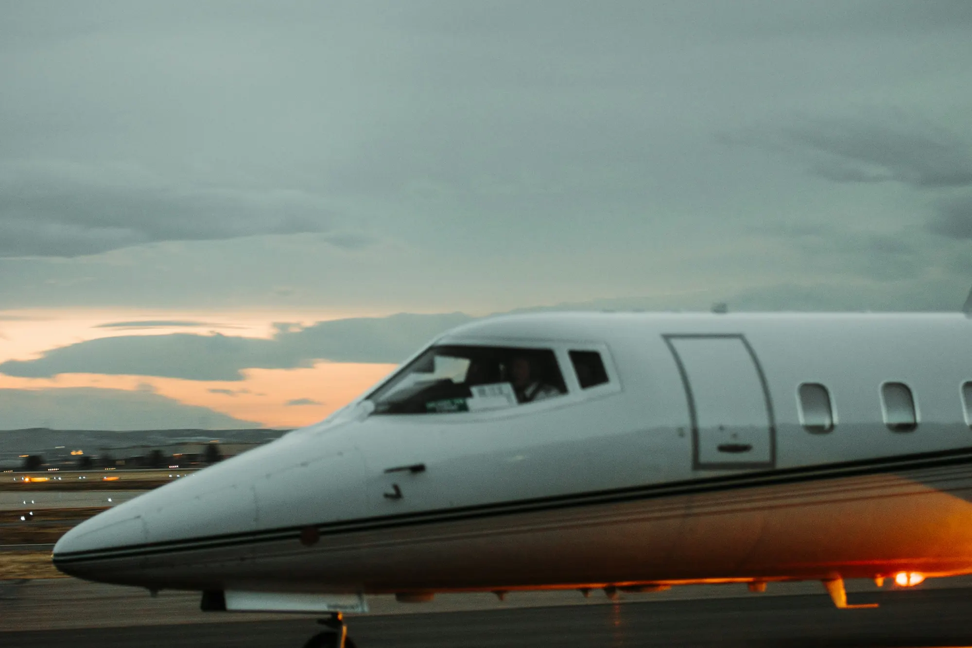 A light business jet on the runway at dusk