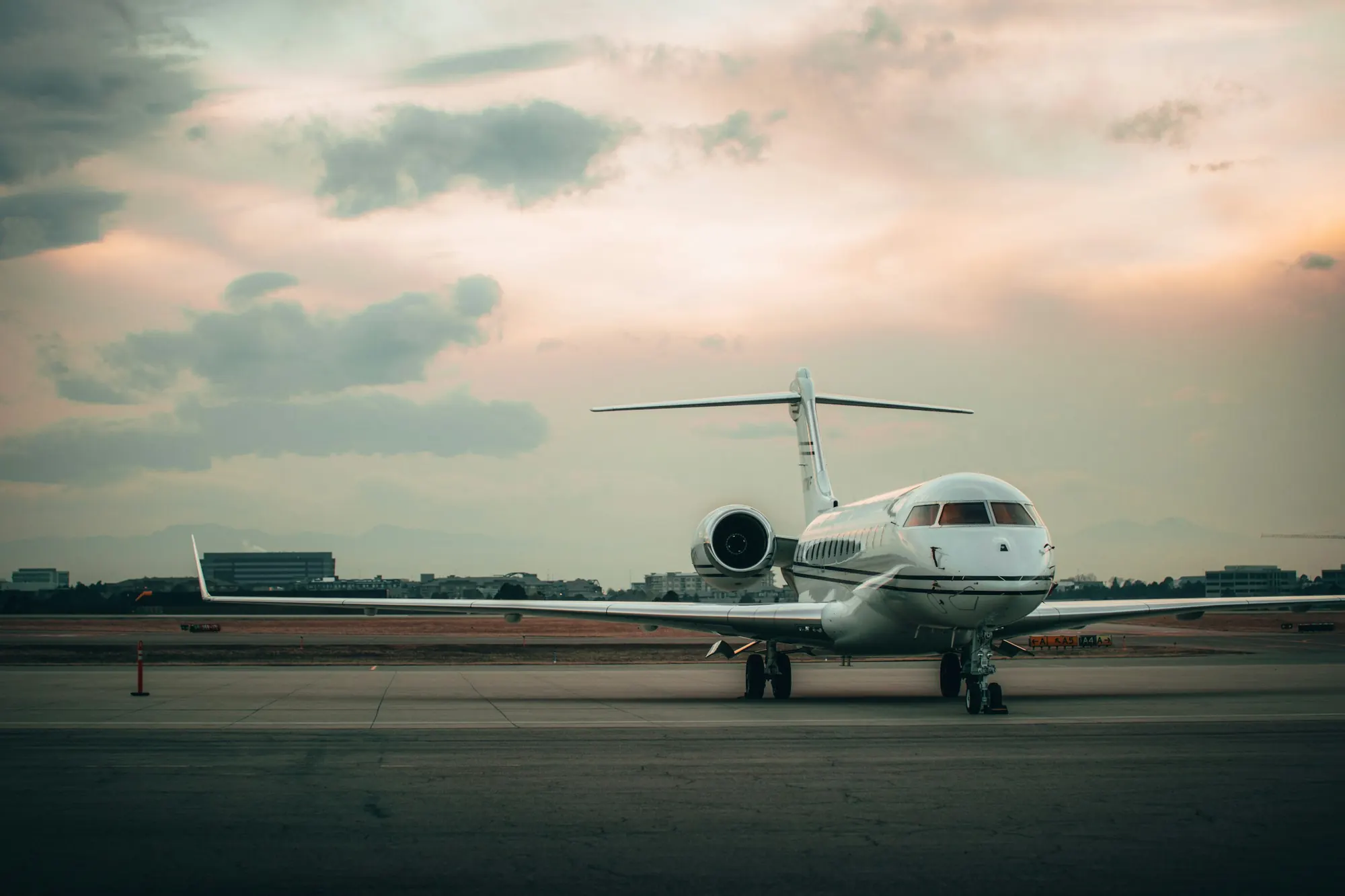 A business jet waiting on an empty ramp at dusk