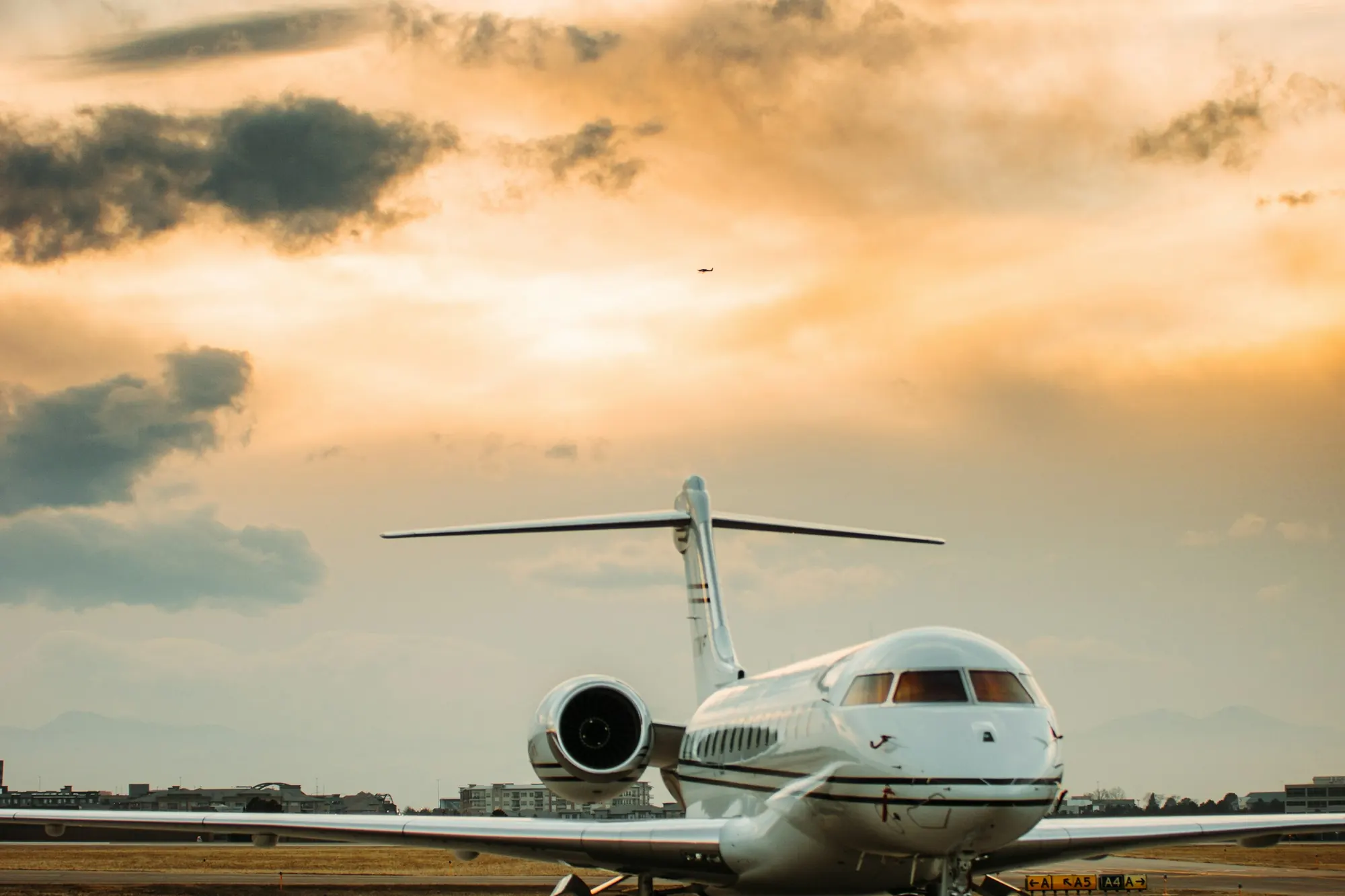 A small business jet on the ramp at sunset